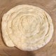 The dough, once it’s been flipped off the board and onto the parchment paper.